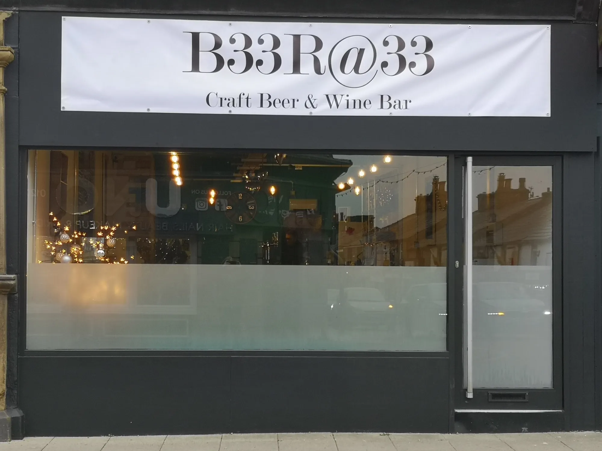 The dark shopfront on Lee Lane with its B33R@33 Craft Beer and Wine Bar sign, a pub in Horwich
