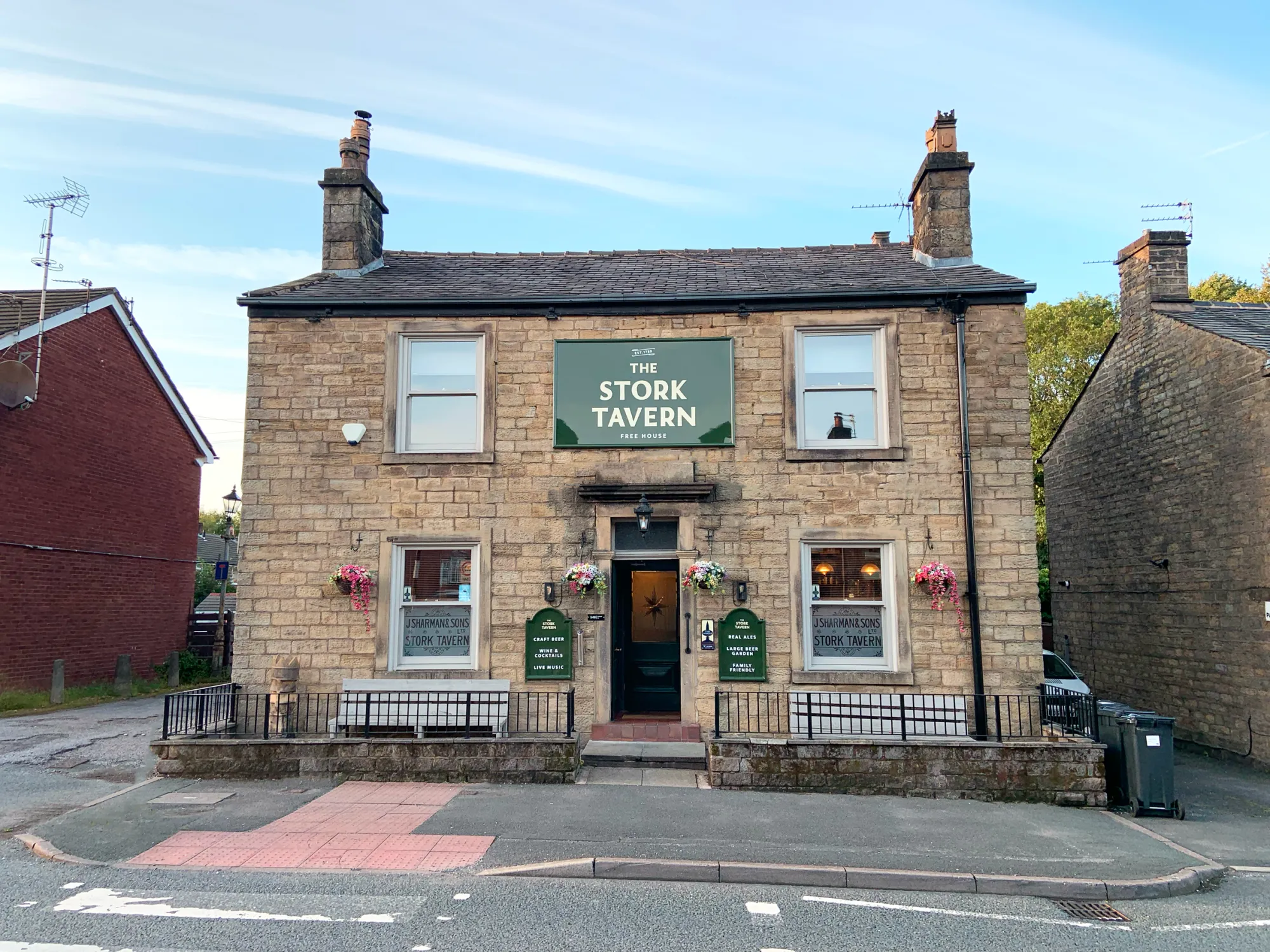 The stone front of the Stork Tavern on Halliwell Road with its green Stork Tavern sign, a pub in Bolton