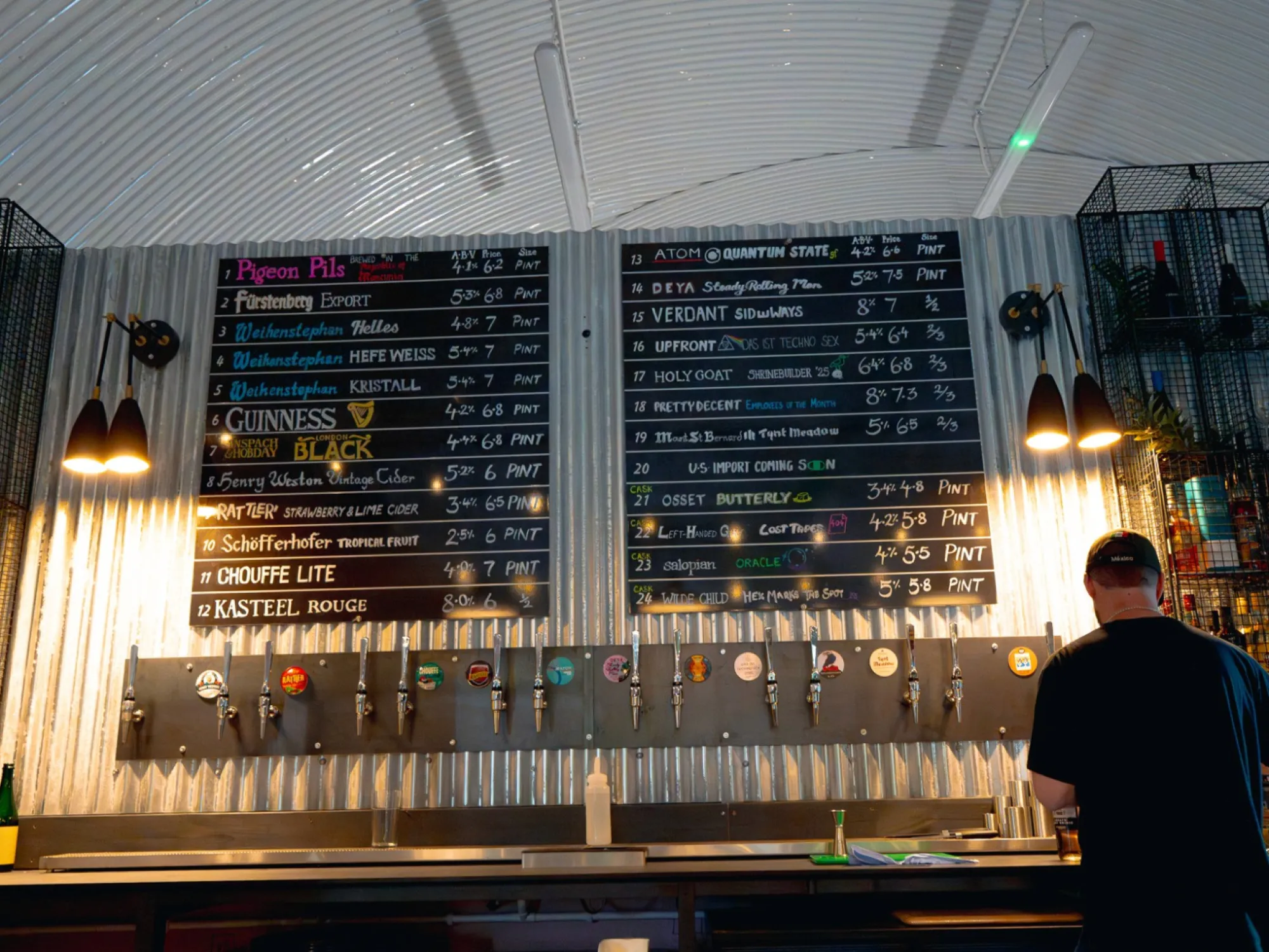 The tap wall and chalkboard beer lists under the railway arch at Pigeon Beer Wanderer, a craft beer bar in Piccadilly, Manchester