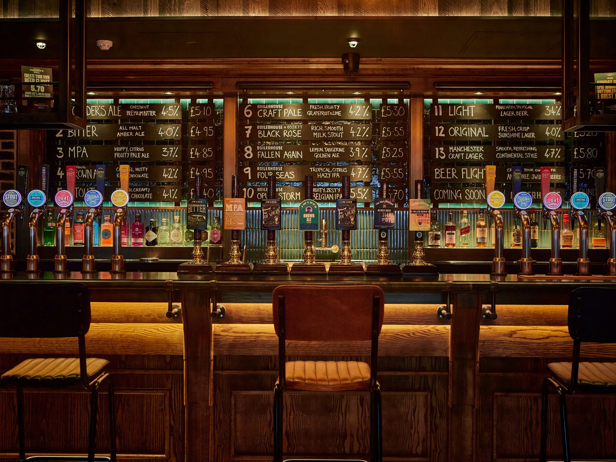 The long bar at Founder's Hall, with a wall of taps and stools in front, a pub in Deansgate, Manchester
