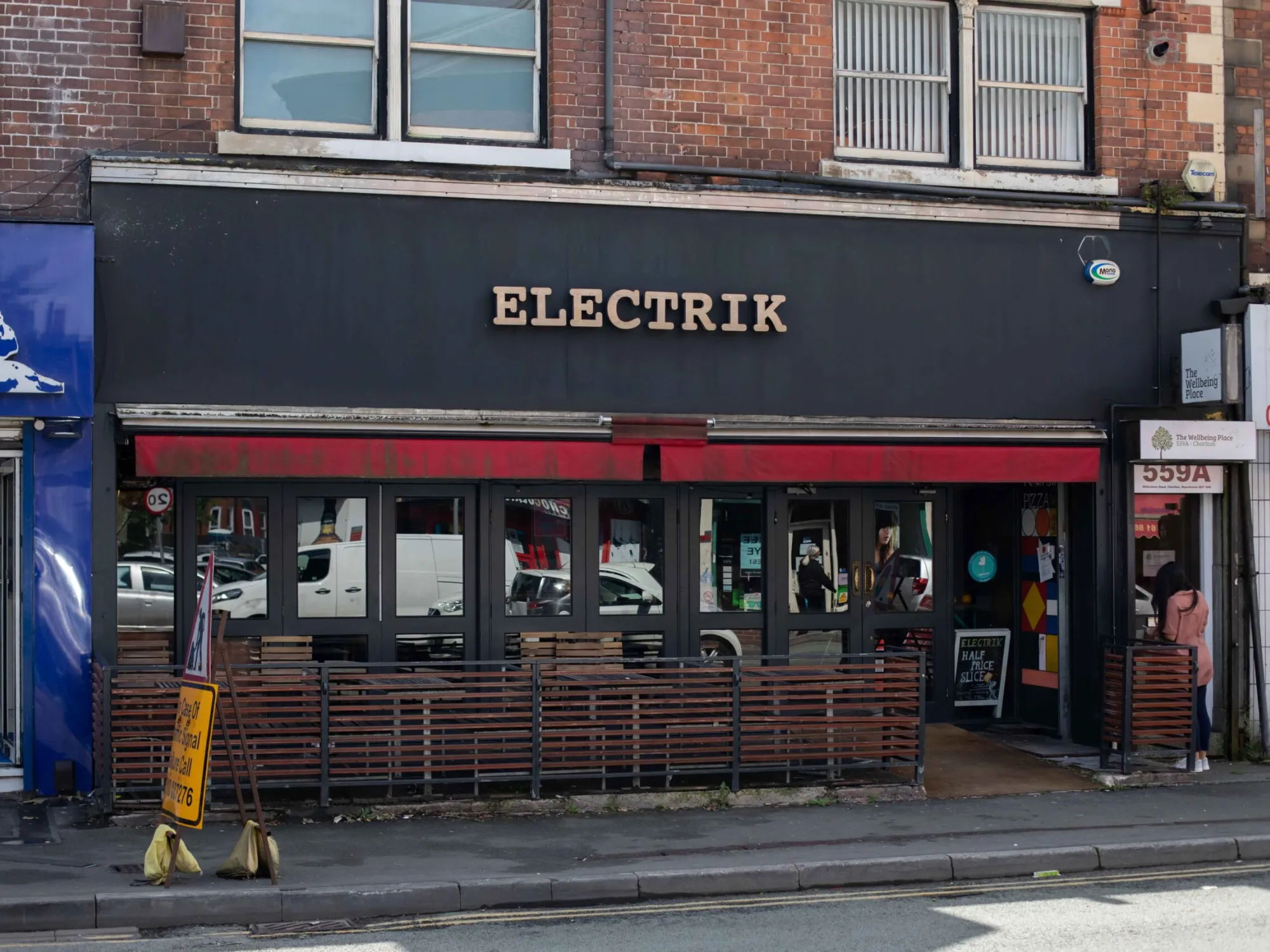 The front of Electrik on Wilbraham Road, with its red awning and terrace, a craft beer bar in Chorlton, Manchester