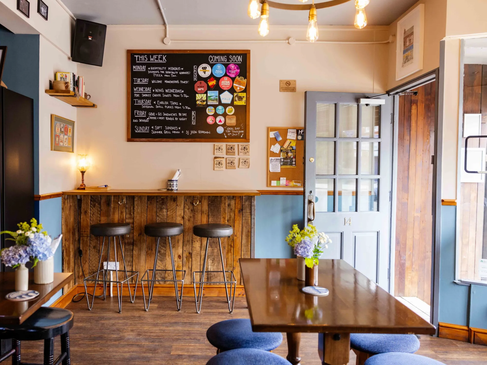 Inside Reddish Ale, with the bar, stools, tap list board and tables, a craft beer bar in Stockport