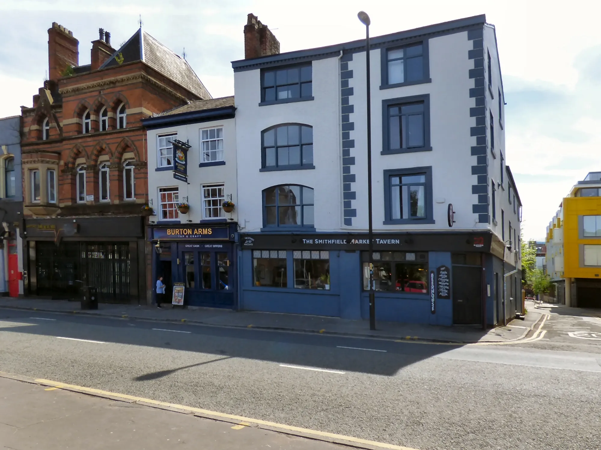 The blue painted front of the Smithfield Market Tavern on Swan Street, beside the Burton Arms, a pub in the Northern Quarter, Manchester