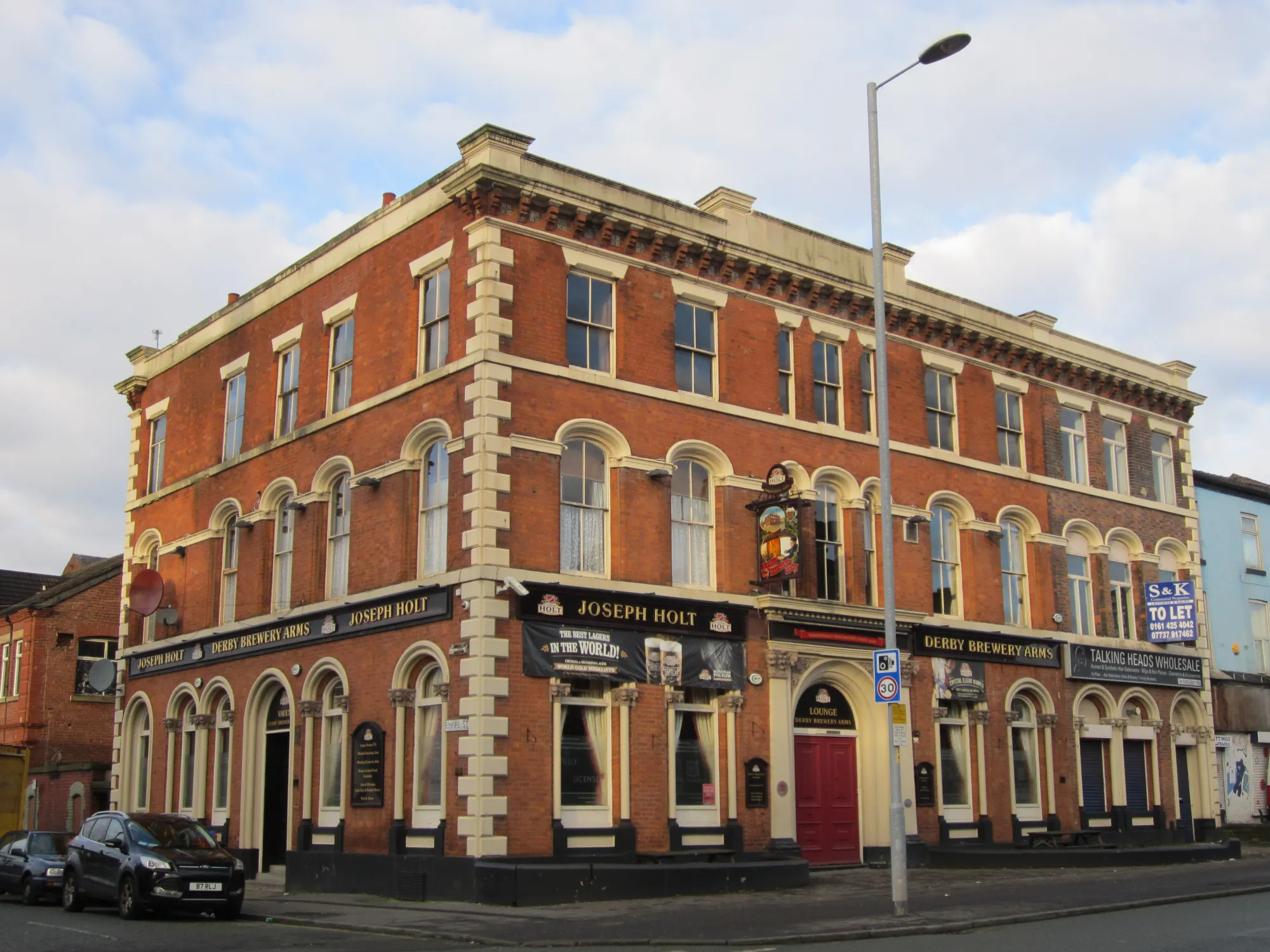 The red brick and cream corner front of the Derby Brewery Arms on Cheetham Hill Road, a pub in Cheetham Hill, Manchester