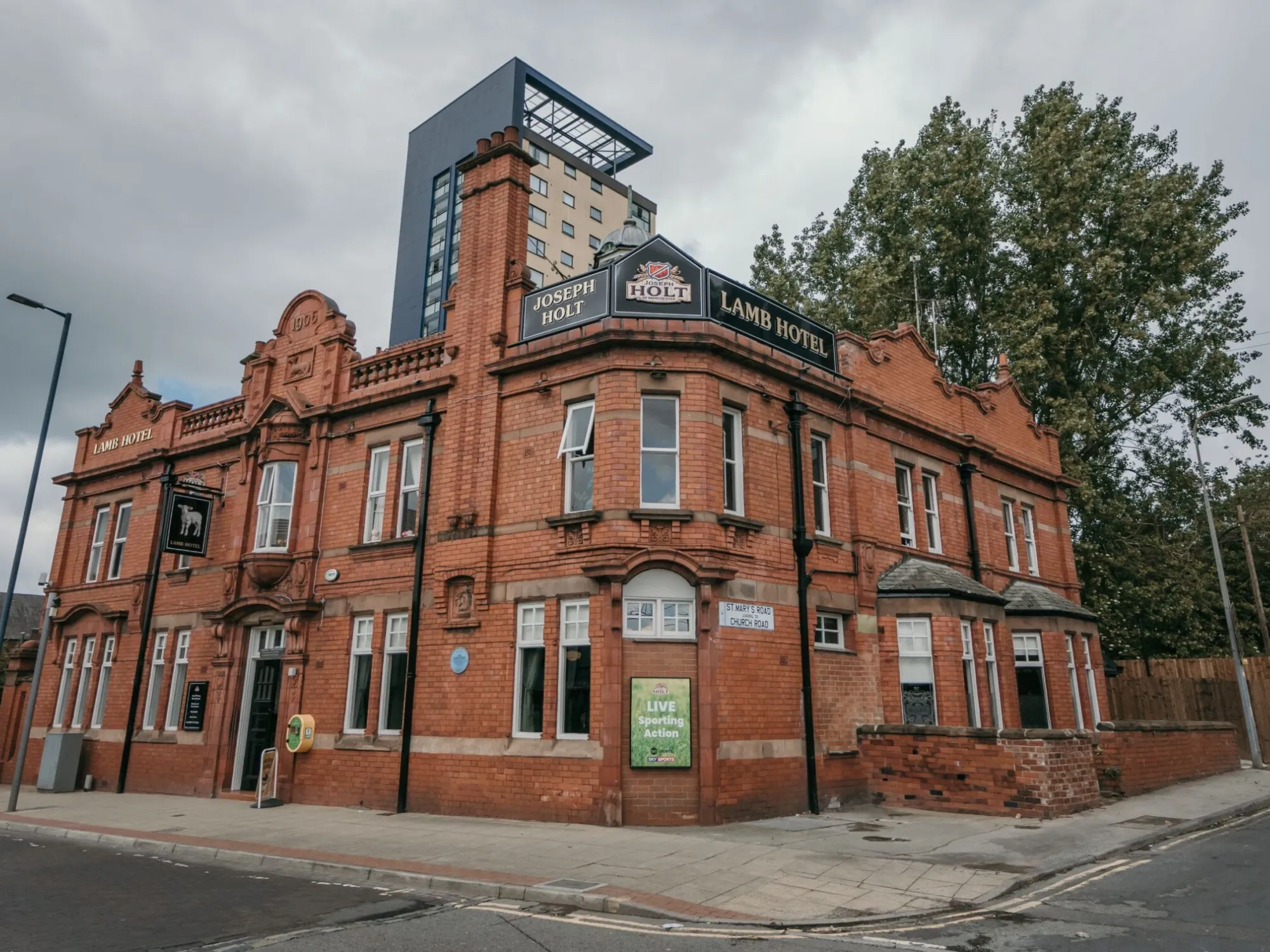 The red-brick and terracotta corner front of the Lamb Hotel on Regent Street, a pub in Eccles